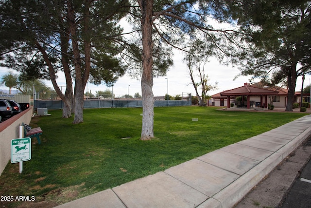 view of property's community with a lawn, a gazebo, and fence