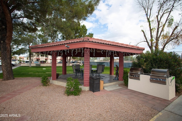 view of property's community with a patio area, a lawn, exterior kitchen, and a gazebo