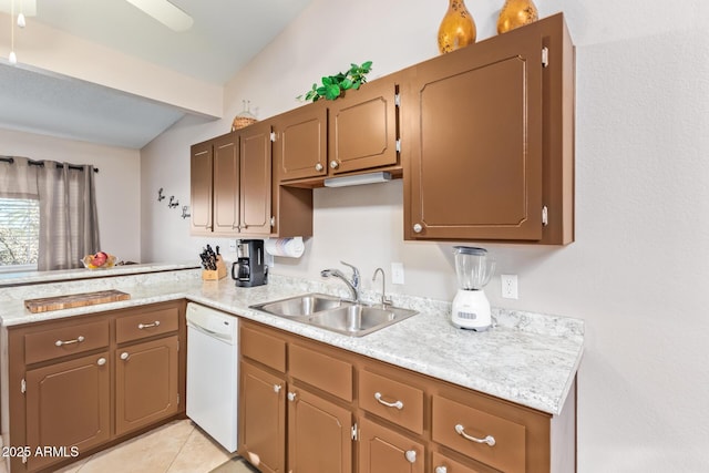 kitchen featuring a peninsula, white dishwasher, light countertops, and a sink