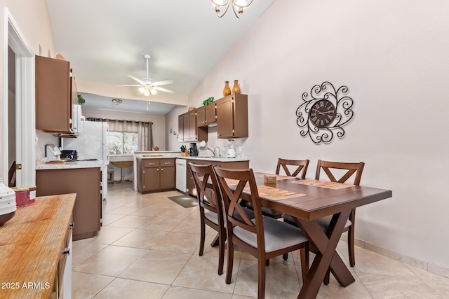 dining space with lofted ceiling, ceiling fan, baseboards, and light tile patterned floors