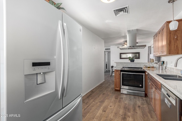 kitchen featuring wood-type flooring, sink, hanging light fixtures, island exhaust hood, and stainless steel appliances