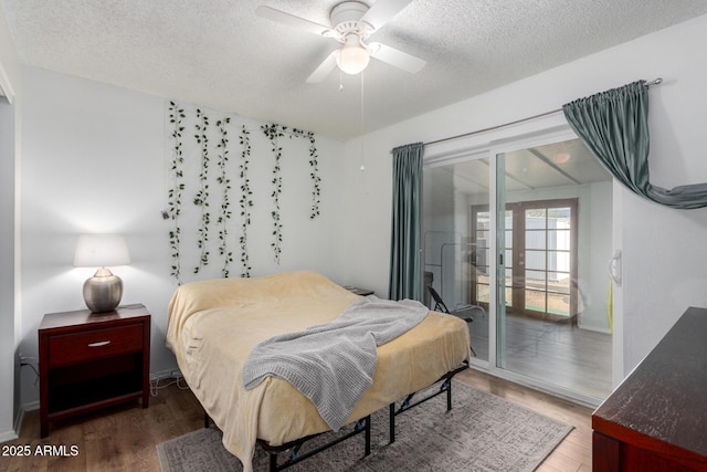 bedroom with dark wood-type flooring, ceiling fan, access to exterior, and a textured ceiling