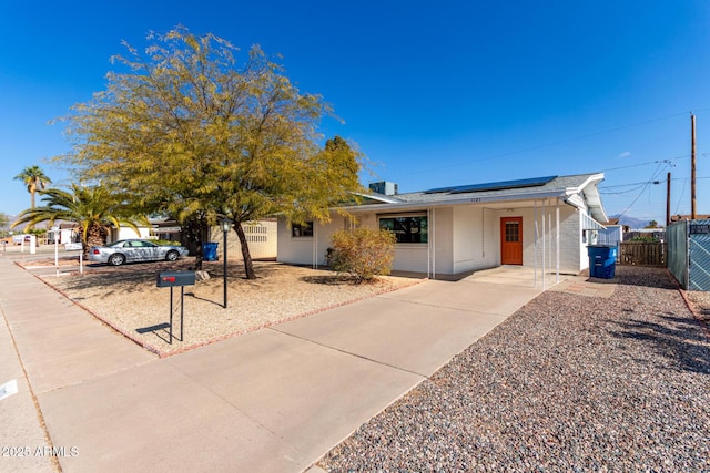 ranch-style home featuring solar panels