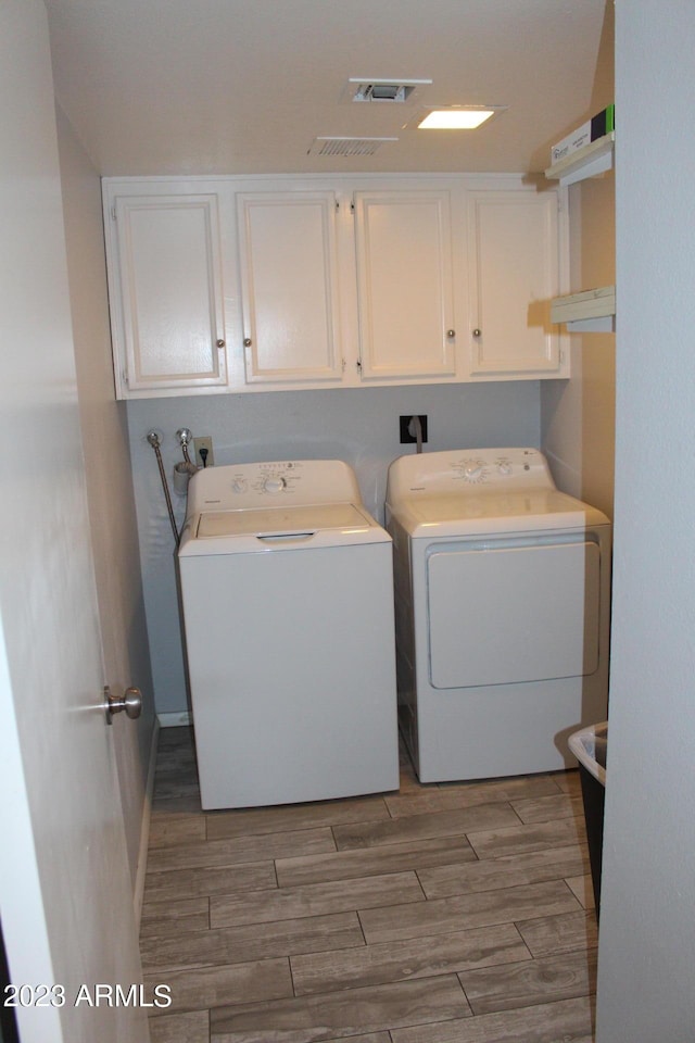 7120 E Wilshire Dr Unit 10, Scottsdale, AZ 85257 - laundry room featuring cabinet space, separate washer and dryer, and wood finished floors
