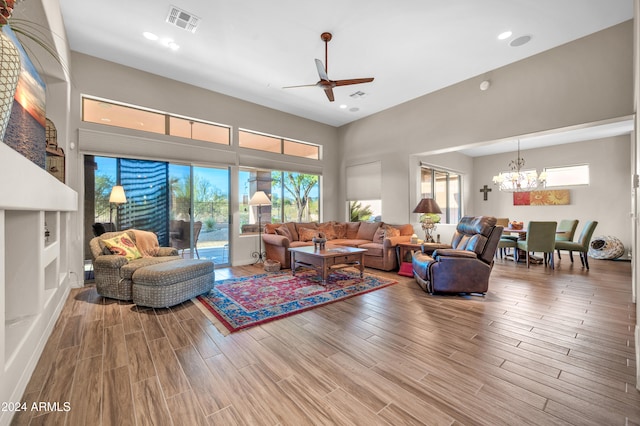 living room with wood-type flooring and ceiling fan with notable chandelier