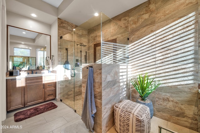 bathroom featuring tile patterned flooring, vanity, and a shower with shower door