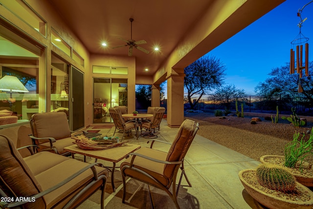 patio terrace at dusk with an outdoor living space and ceiling fan