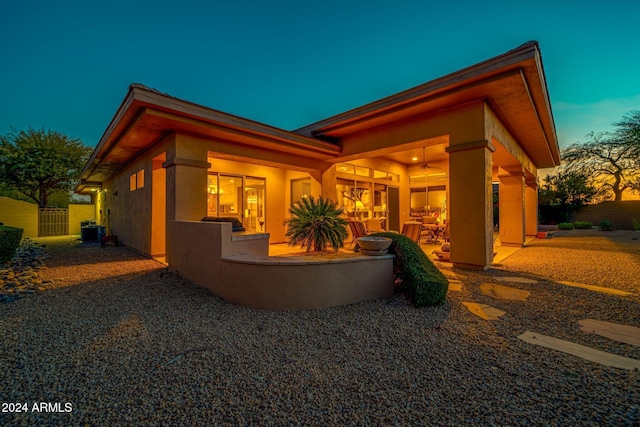 back house at dusk with a patio area