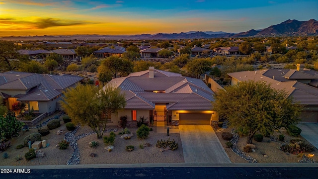 aerial view at dusk featuring a mountain view