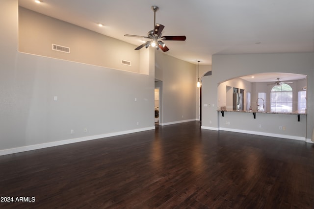 unfurnished living room with high vaulted ceiling, ceiling fan, and dark hardwood / wood-style floors