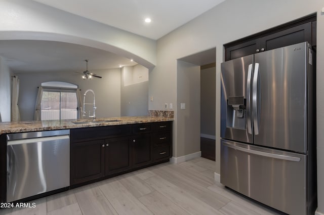 kitchen featuring ceiling fan, light hardwood / wood-style flooring, light stone counters, sink, and stainless steel appliances