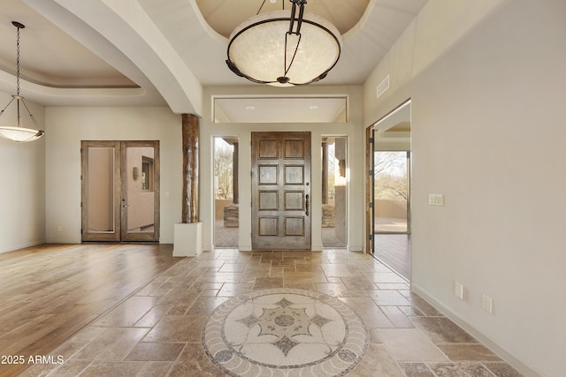 entryway featuring a raised ceiling and french doors