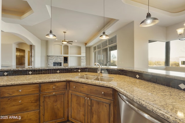 kitchen with dishwasher, decorative light fixtures, a raised ceiling, and sink