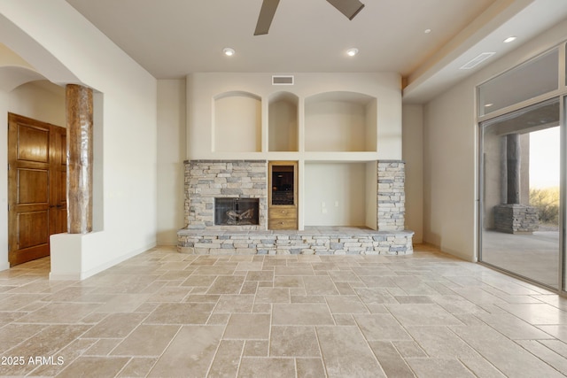 unfurnished living room with a fireplace and ceiling fan