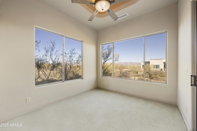 unfurnished room featuring light colored carpet and ceiling fan