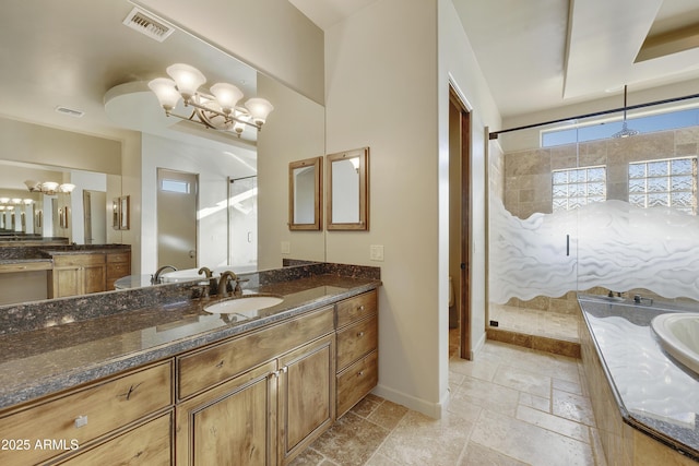 bathroom featuring a notable chandelier, a shower with door, and vanity