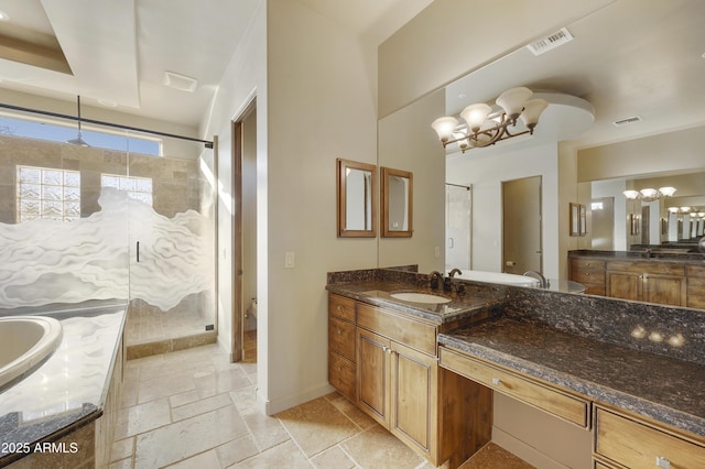 bathroom with a chandelier, vanity, and walk in shower