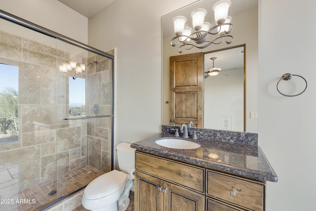 bathroom featuring vanity, ceiling fan with notable chandelier, an enclosed shower, and a wealth of natural light