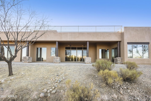 back of property with ceiling fan