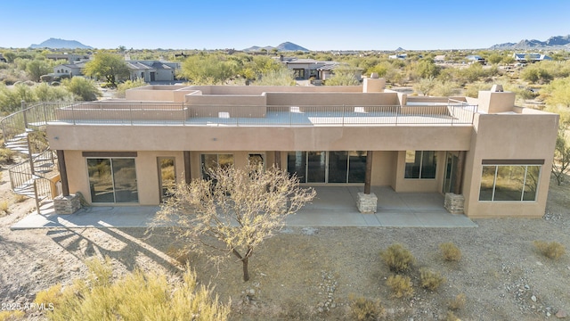 rear view of house featuring a mountain view and a patio