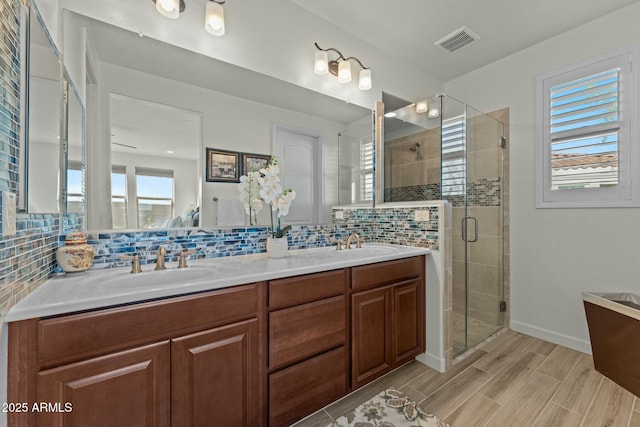 20701 W Minnezona Ave, Buckeye, AZ 85396 - full bath featuring a stall shower, tasteful backsplash, visible vents, and a sink