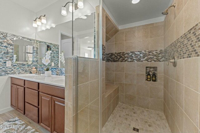 20701 W Minnezona Ave, Buckeye, AZ 85396 - bathroom featuring a tile shower, a sink, tasteful backsplash, and double vanity