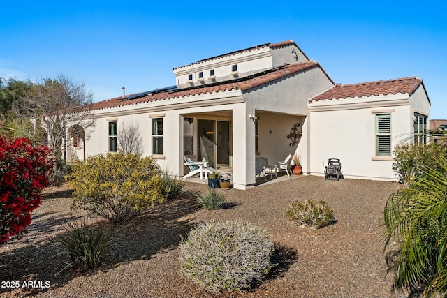 20701 W Minnezona Ave, Buckeye, AZ 85396 - back of property with a tile roof, stucco siding, roof mounted solar panels, and a patio
