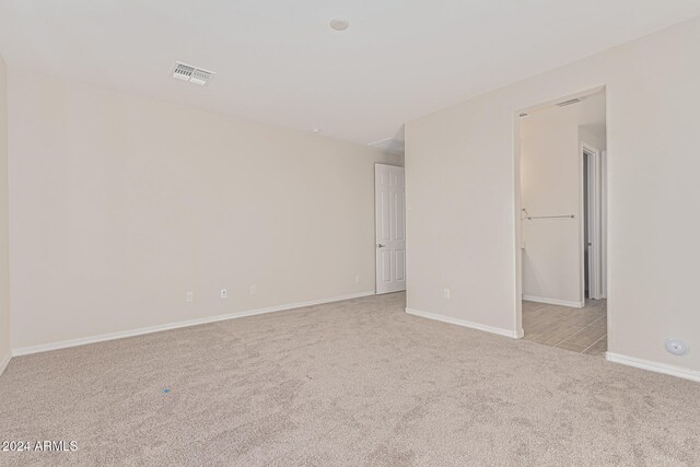 unfurnished room featuring light carpet