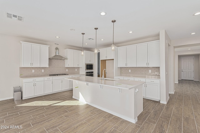 kitchen with white cabinets and wall chimney range hood