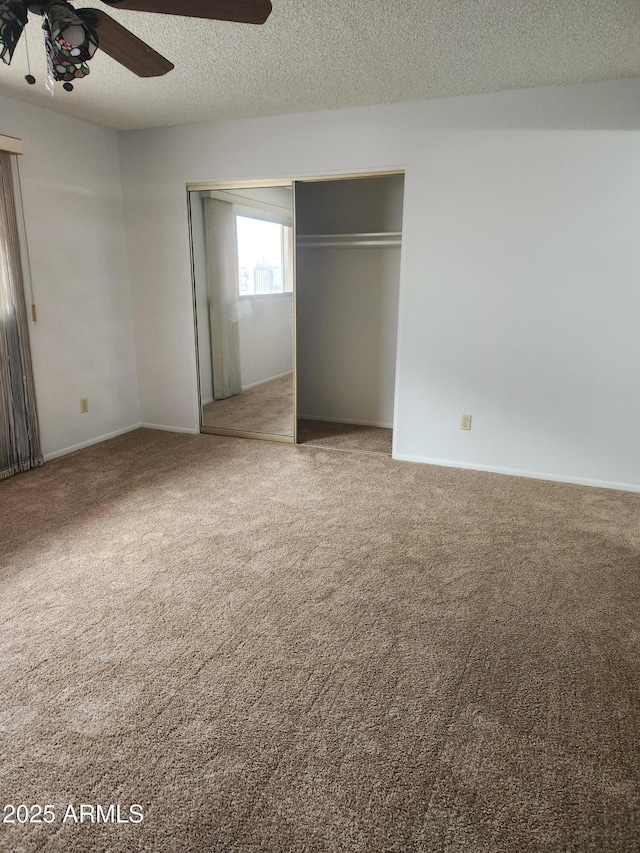 unfurnished bedroom with a ceiling fan, a closet, carpet flooring, and a textured ceiling