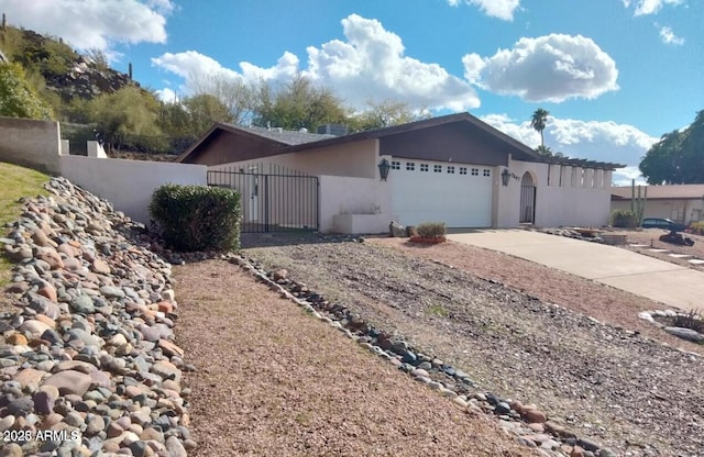 view of front of home featuring concrete driveway, a fenced front yard, an attached garage, and stucco siding