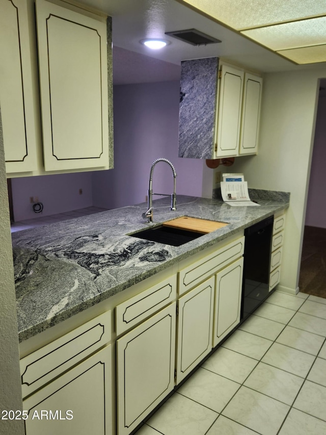 kitchen featuring dishwasher, light tile patterned floors, visible vents, and a sink