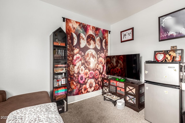 bedroom with carpet floors and freestanding refrigerator