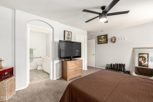 carpeted bedroom featuring baseboards, a ceiling fan, and connected bathroom