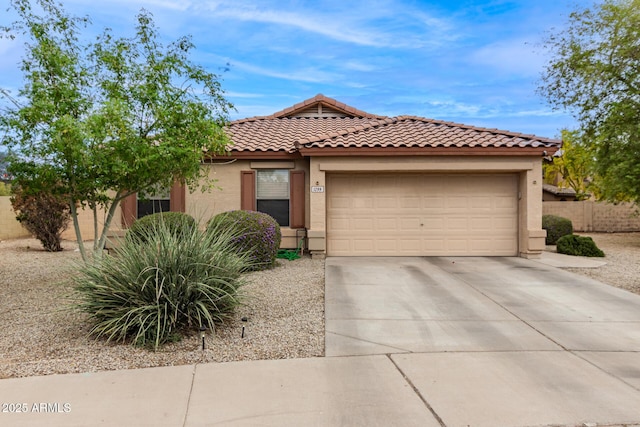 mediterranean / spanish home with a garage, driveway, stucco siding, and a tile roof