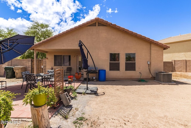 rear view of property featuring cooling unit, a patio, stucco siding, and fence
