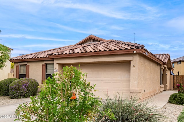 view of front facade featuring an attached garage, stucco siding, and a tile roof