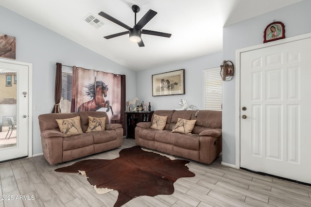living area with visible vents, light wood-type flooring, vaulted ceiling, and ceiling fan