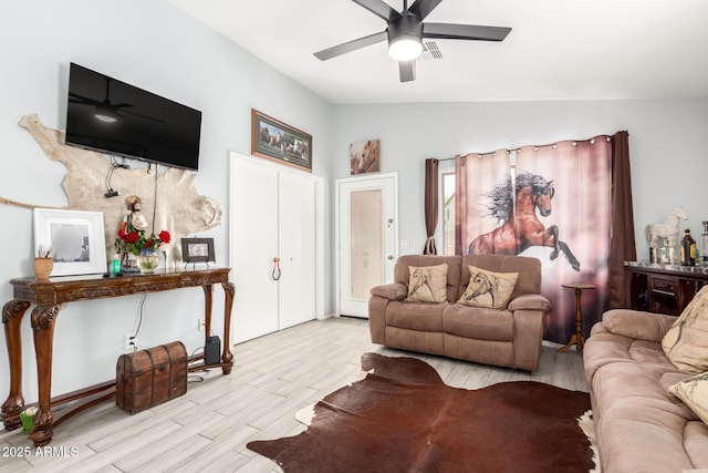 living area featuring vaulted ceiling, a ceiling fan, and wood finished floors