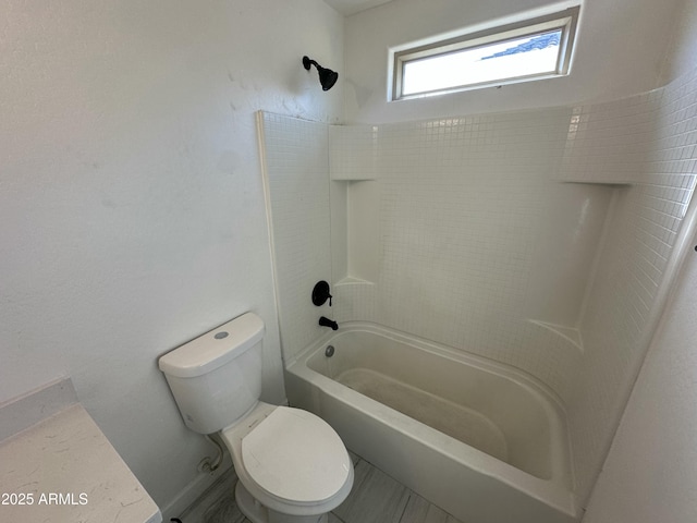 bathroom with toilet and bathing tub / shower combination