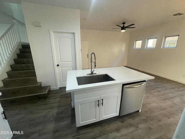 kitchen featuring sink, white cabinetry, stainless steel dishwasher, a kitchen island with sink, and dark wood-type flooring