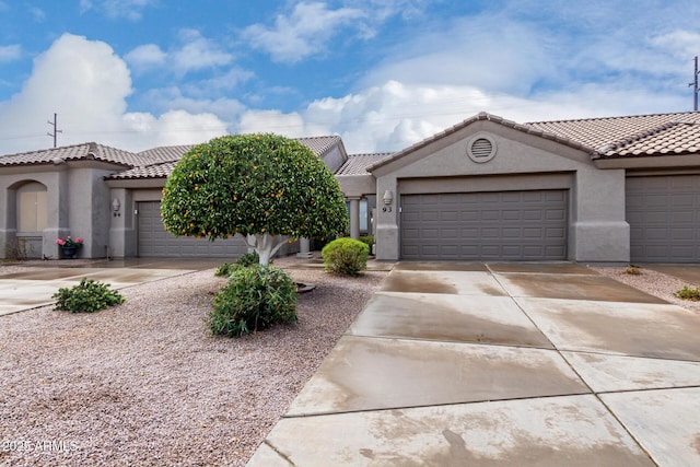 view of front of property featuring a tiled roof, stucco siding, an attached garage, and concrete driveway