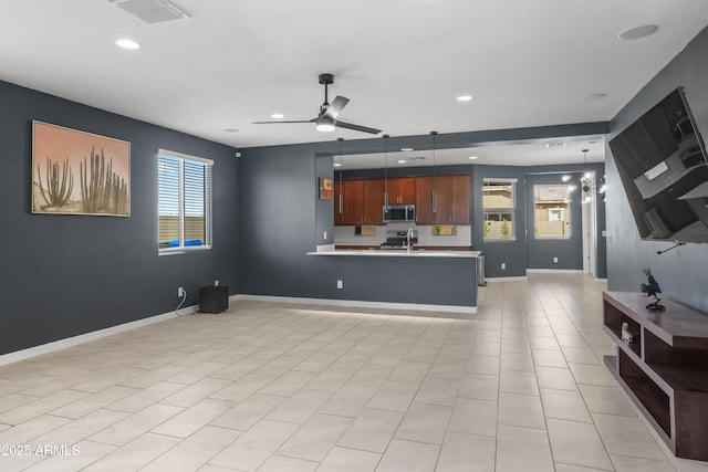 unfurnished living room with recessed lighting, visible vents, baseboards, and ceiling fan with notable chandelier