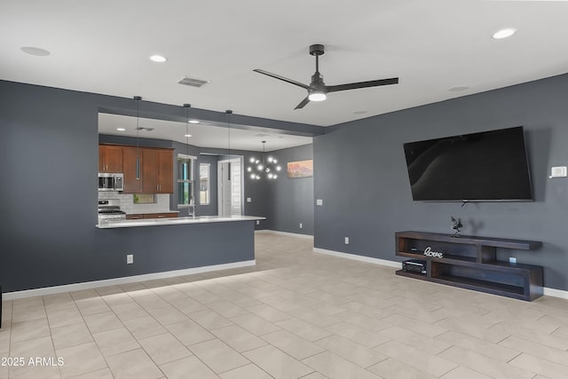 unfurnished living room featuring recessed lighting, a sink, a ceiling fan, visible vents, and baseboards