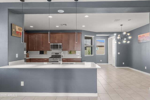 kitchen with appliances with stainless steel finishes, light countertops, visible vents, and a sink