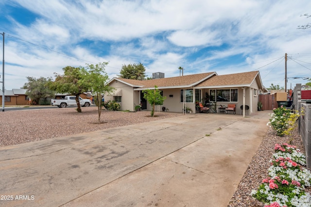 ranch-style house with driveway and fence