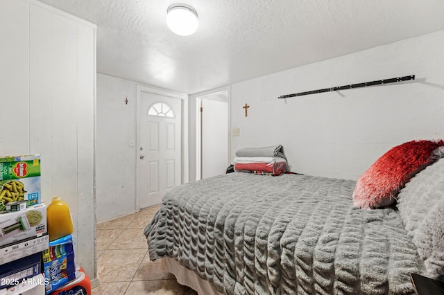 bedroom with light tile patterned floors and a textured ceiling