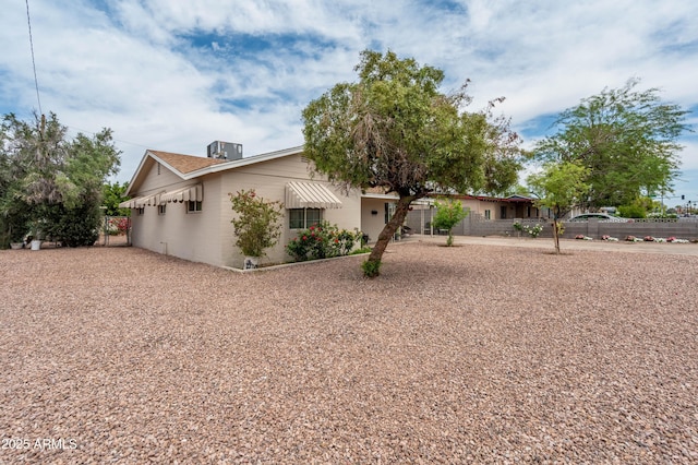 view of front of home featuring central AC unit and fence