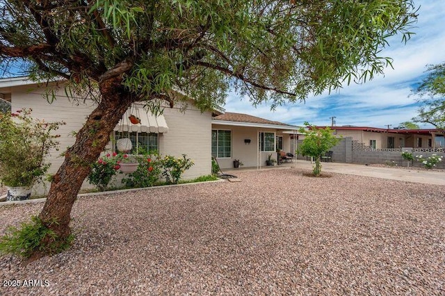 ranch-style house featuring fence