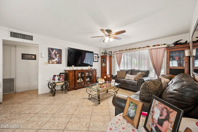 living room featuring light tile patterned floors, visible vents, and ceiling fan